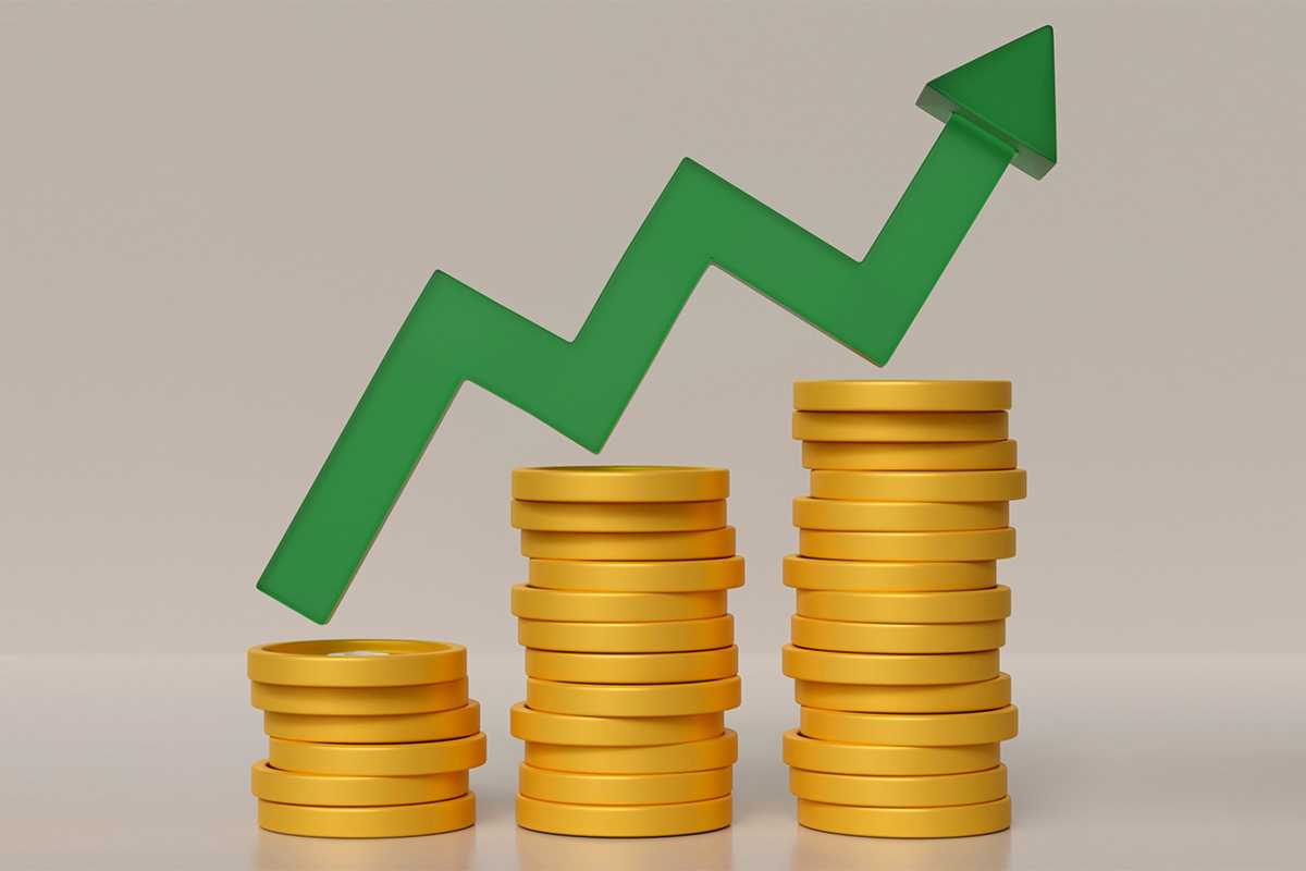 Illustration of three piles of gold coins increasing in height from left to right. Above, a green arrow tracks an up-and-down trend, generally upwards