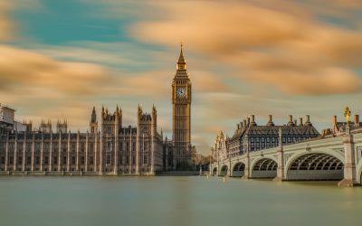 A scene of London Parliament at dusk with sunset orange clouds in a blue sky