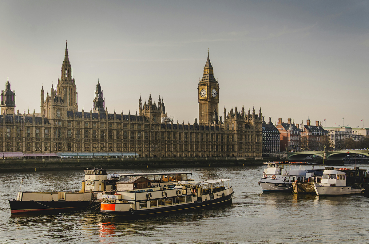 The Houses of Parliament in London with the River Thames in front with boats on