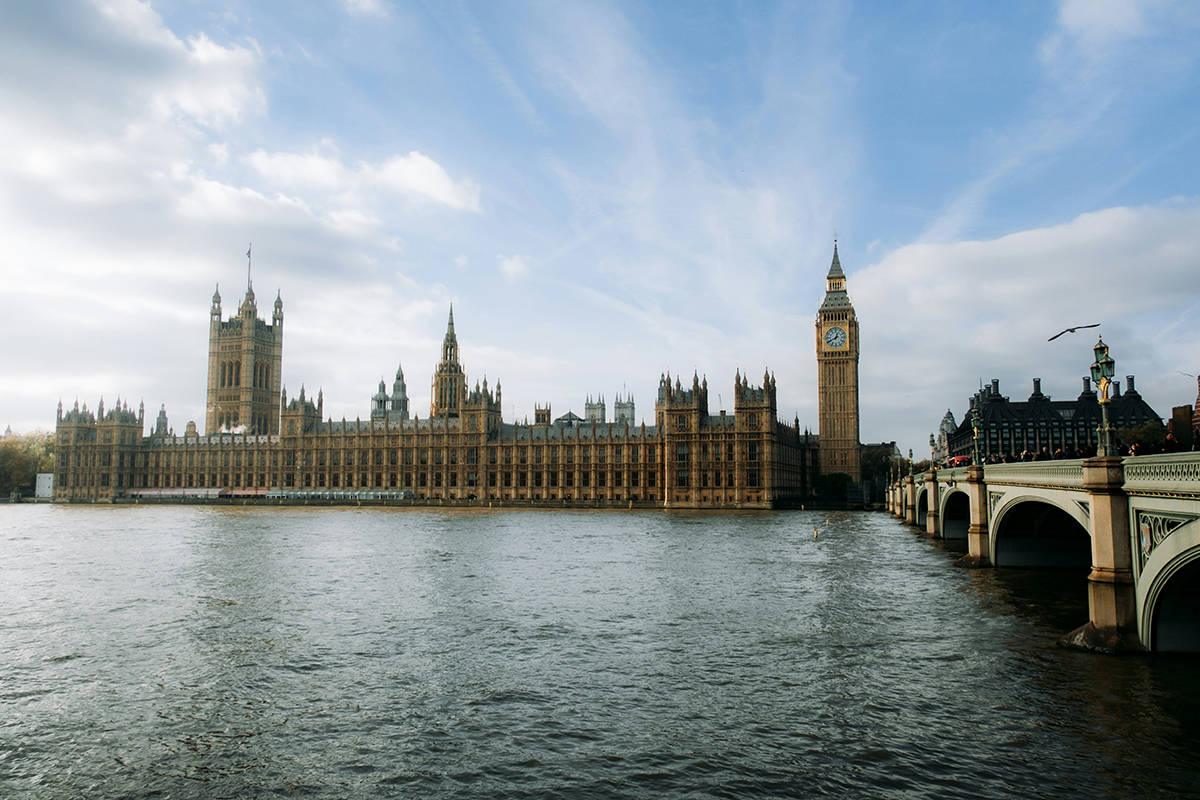 The Houses of Parliament from across the Thames with a blue sky behind