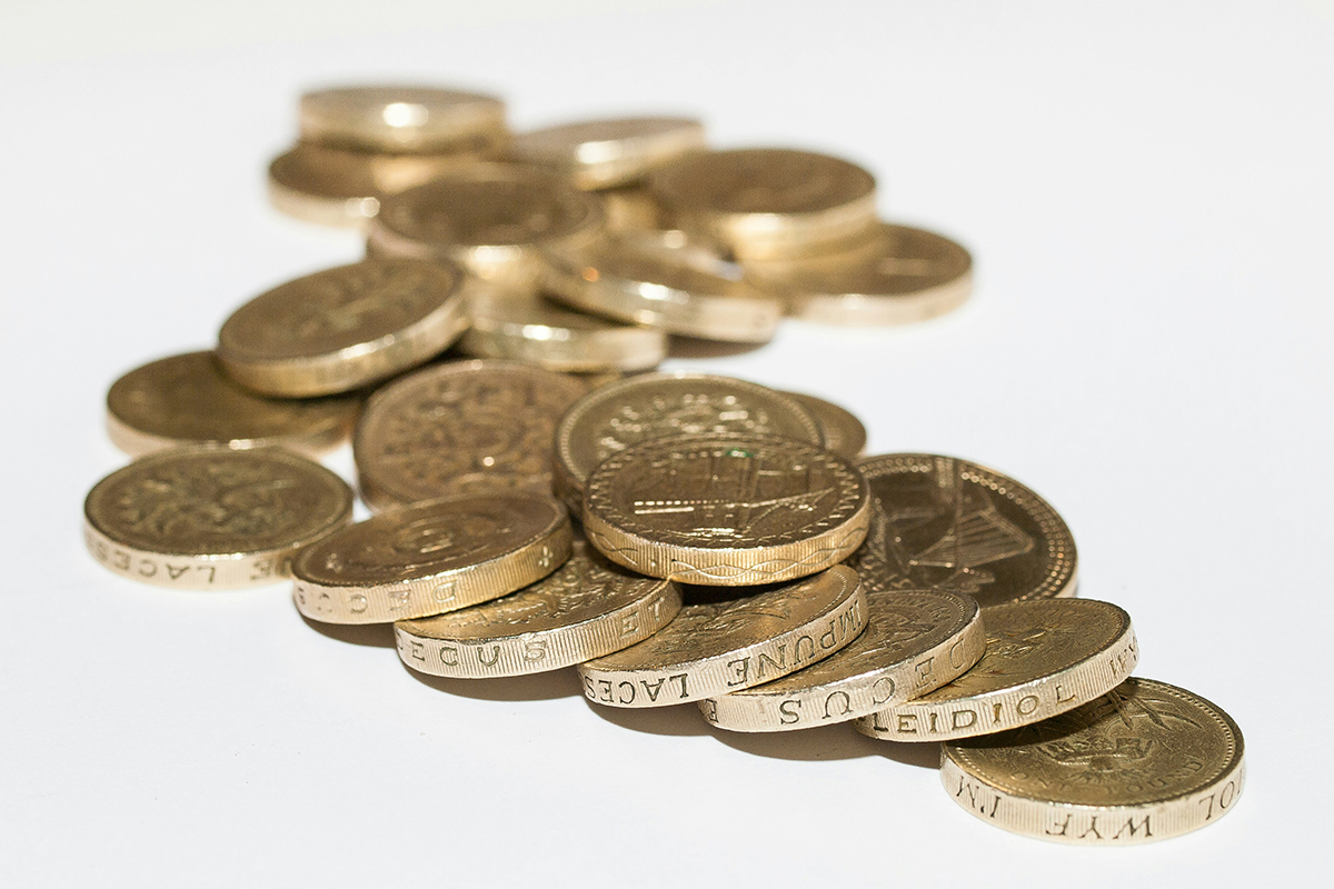 A pile of gold coins laid on a white background